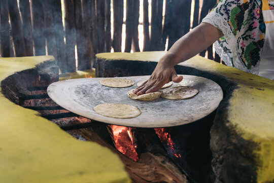 Authentic Mexican handmade tortillas in a traditional rustic wood stove called "fogon"