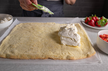 Woman spreading a filling on a sponge cake base