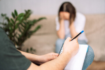 Fototapeta premium Girl at meeting with psychologist with notebook and pen.