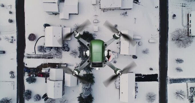 A top-down view of a small drone UAV flying over homes in the winter.	