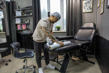 Fototapeta premium Young man preparing for tattoo session