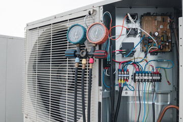 Technician is checking air conditioner,measuring equipment for filling air conditioners.