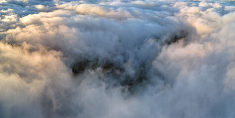 Plakat Aerial view from airplane window at high altitude of dense puffy cumulus clouds flying in evening