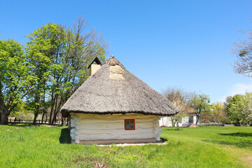 Whitewashed house with a thatched roof from Middle Transnistria in skansen Pirogovo in Kyiv, Ukraine	