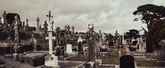 An cemetery in Ireland. Stone tombstones, Celtic cross. Christian cemetery, cloudy sky