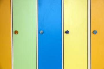 Close up of colorful lockers doors with funny animals as door knobs in day care school