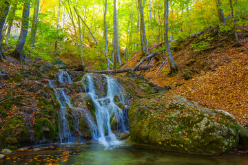 small waterfall  in autumn mountain canyon, seasonal mountain travel scene