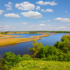 view fhom green hill to the blue river among prairie under blue cloudy sky
