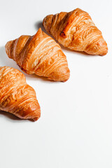 Three delicious croissant crisp in butter on a white background with a place for dyal text