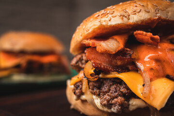 Amazing American traditional smash burger with melted cheddar cheese, bacon, grilled onions and sauce. - obrazy, fototapety, plakaty