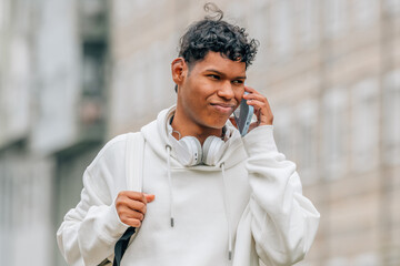 young latino male on the street talking on a mobile phone