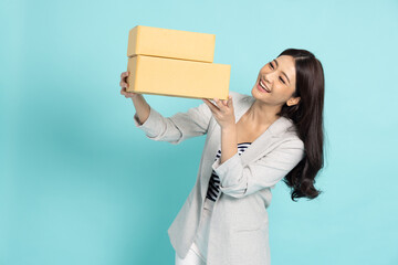 Happy Asian woman holding package parcel box isolated on green background, Delivery courier and shipping service concept