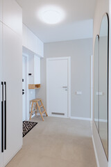 White interior corridor in a house with white doors and closet