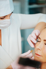 Obraz na płótnie Canvas Filler injection procedure under the skin of a woman to combat age-related skin aging - rejuvenating effect