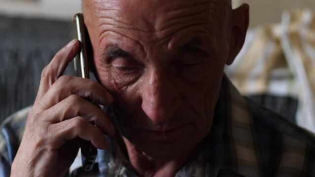 portrait of a depressed sad pensioner listening to an interlocutor on the phone. Frustrated senior adult pensioner feeling frustrated while talking desperately on the phone