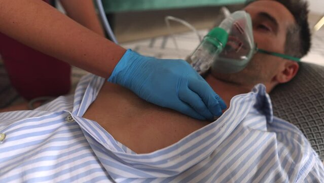 Emergency help for unconscious man, doctor's examination, heart attack emergency at home, man receiving oxygen, breathing problems