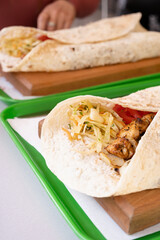 Grilled kebab with pita bread and vegetables on tray in summer fast food street cafe
