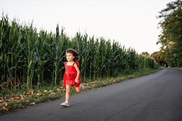 Fototapeta premium girl in red dress running on the country road