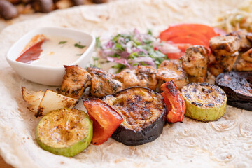 Grilled kebab with pita bread and vegetables on tray in summer fast food street cafe