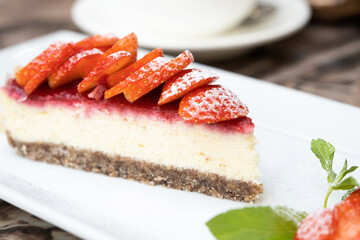 Piece of delicious cheesecake with berries on table close up