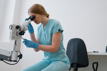 Professional gynecologist woman examines patient with colposcope in gynecology clinic medicine and health concept