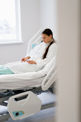 young sick girl patient presses emergency call button and calls nurse for help in hospital ward in...