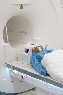The doctor performs an MRI scan for a patient at the clinic Magnetic resonance imaging in the study of the human body
