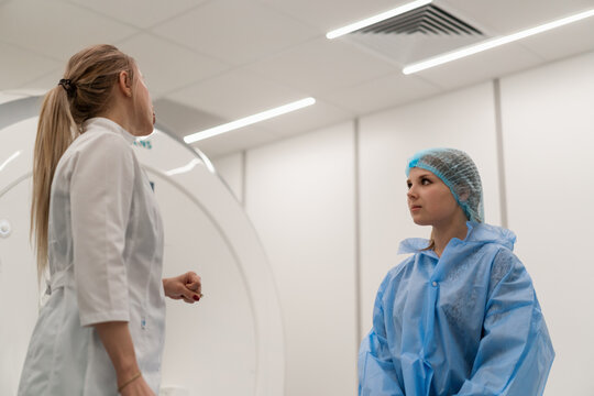 A professional radiologist in a medical clinic advises a patient before the magnetic resonance imaging procedure