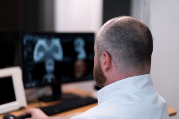 the patient undergoes computed tomography in the clinic the radiologist monitors the procedure and...