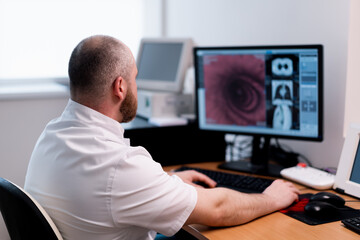 the patient undergoes computed tomography in the clinic the radiologist monitors the procedure and...