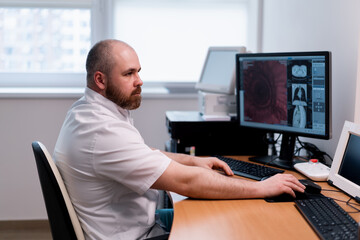 the patient undergoes computed tomography in the clinic the radiologist monitors the procedure and...