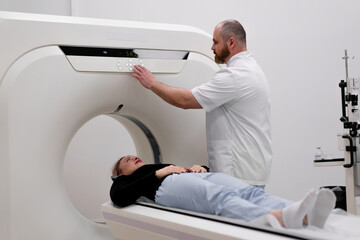 A radiologist performs a computer tomography procedure in a medical clinic A head examination is...