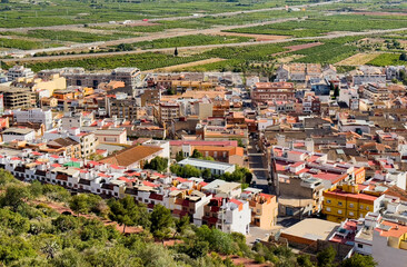 Buildings, houses and streets in city, aerial view. View of rooftops and streets of Almenara town in Spain. Roofs of houses and roofs from mountains side of Castle. View of the city from mountain.