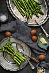 Green asparagus,  eggs, bread, butter, vintage crockery. Top view. Rustic food photography.