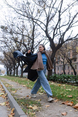 Young woman walking outdoor, in autumn city.