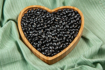 heart shaped black bean bowl on green tablecloth
