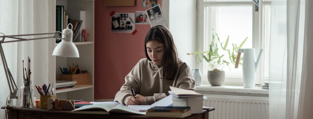 Fototapeta na wymiar Young teenage girl studying in her room.