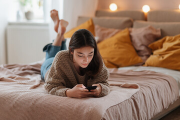 Young teenage girl srolling her smartphone in the room.
