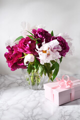 Bouquet of beautiful peonies with gift