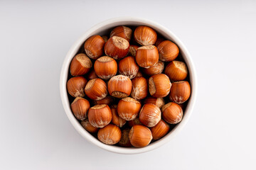 In shell hazelnuts bowl. Up view studio shoot isolated on white background.