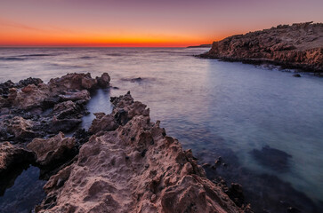 rocks beach sunset over the sea