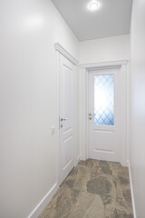 empty corridor with white walls and a door