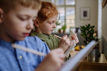 Close up of students writing notes in to their notepads.