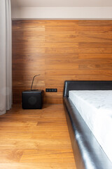 part of the bedroom interior, wooden wall decoration, leather black bed