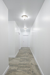 empty corridor with white walls and a door