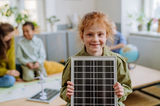 Little girl posing with solar panel during a school lesson.