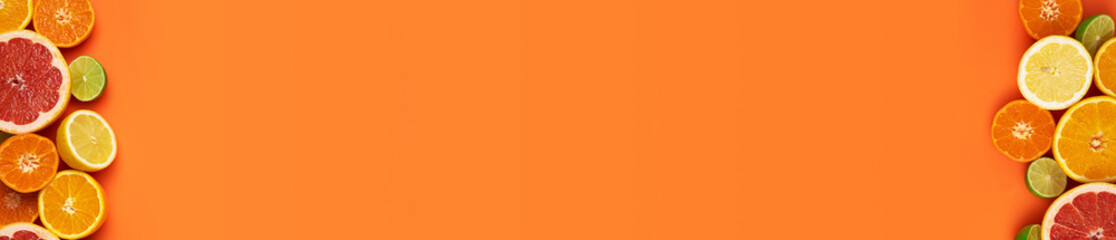 Fresh, Fruity and juicy fruit concept with free text space, web banner. Flat layout with various fresh cut citrus fruits on the left and right side of the picture on an orange background