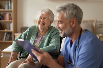 Caregiver doing regular check-up of senior woman in her home.