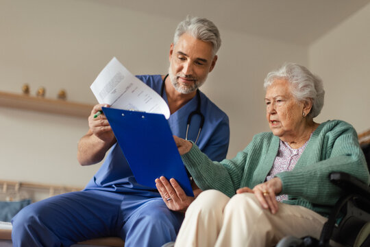 Caregiver doing regular check-up of senior woman in her home.