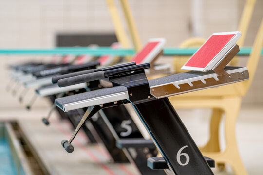 Starting block at a public interior swimming pool / natatorium sports facility.